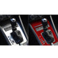 Red carbon-fiber gear shift panel trim with black shift boot and surrounding console area.
