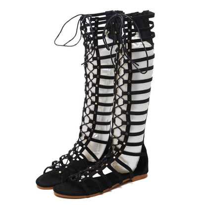Black gladiator-style flat sandals with crisscross hollow straps and lace-up top