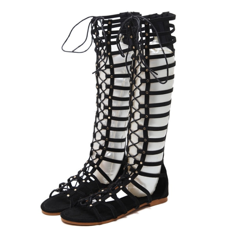 Black gladiator-style flat sandals with open toe, lattice straps, and lace-up closure
