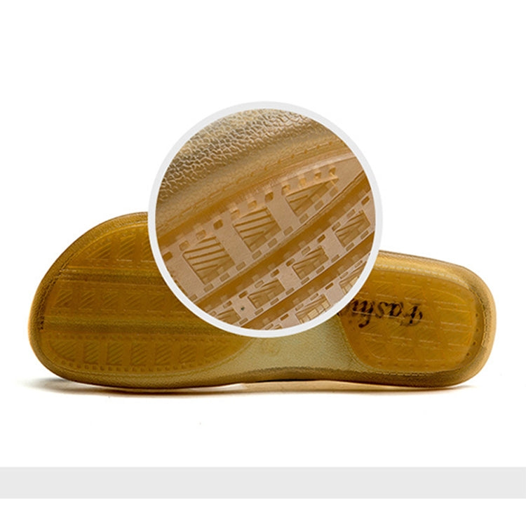 Tan leather slide slippers with patterned outsole, showing underside tread