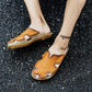 Men's leather sandals with open-toe cut-outs and flat sole, worn on pavement