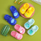 Children’s slip-on slippers in blue, yellow, pink, and white with cartoon accents