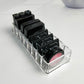 Clear acrylic makeup organizer with divided slots for lipsticks and pink shade