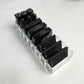 Clear acrylic organizer tray with open compartments for black lipstick tubes