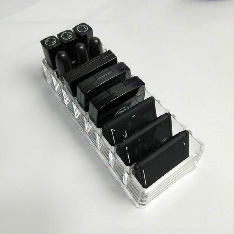 Clear acrylic organizer tray with open compartments for black lipstick tubes