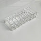Clear acrylic makeup organizer tray with long row of separate compartments