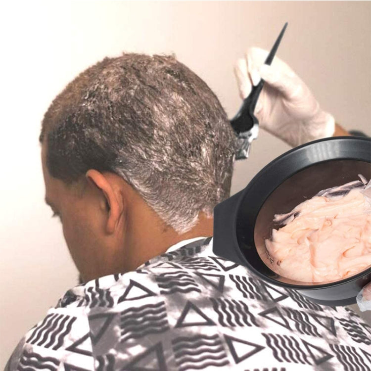 Salon hair dye application using mixing bowl and brush near the scalp