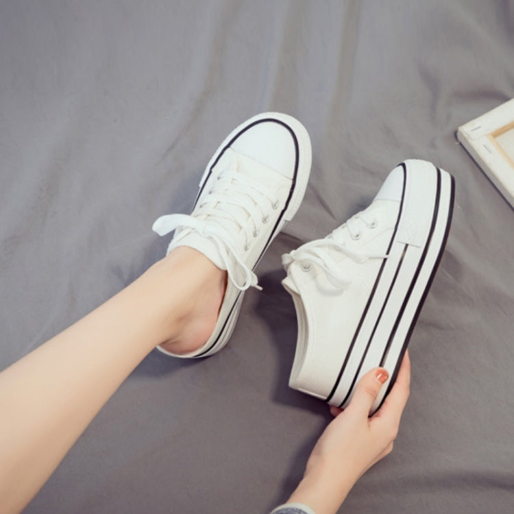 White canvas platform slip-on sneakers on feet, lace-up front and thick sole
