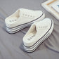 White canvas platform slip-on sneakers with thick stacked sole and black side trim