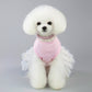 Small dog wearing pink bunny-themed dress with braided scarf collar and star tulle sleeves