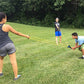 Outdoor water balloon launcher using yellow elastic lines and hand grips.