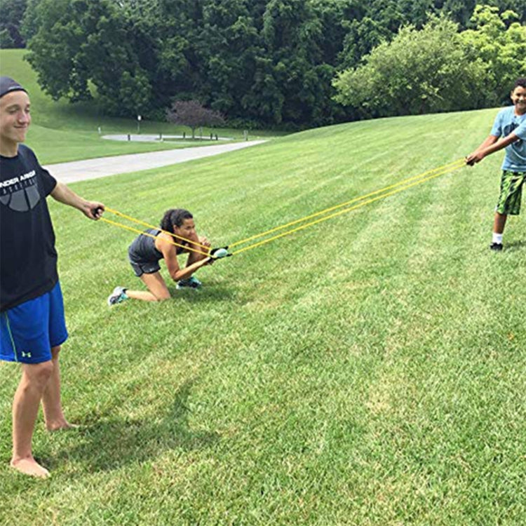 Elastic water balloon launcher setup with yellow cords stretched between players.
