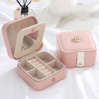 Pink portable leather jewelry box with hinged top, open compartments for earrings and rings