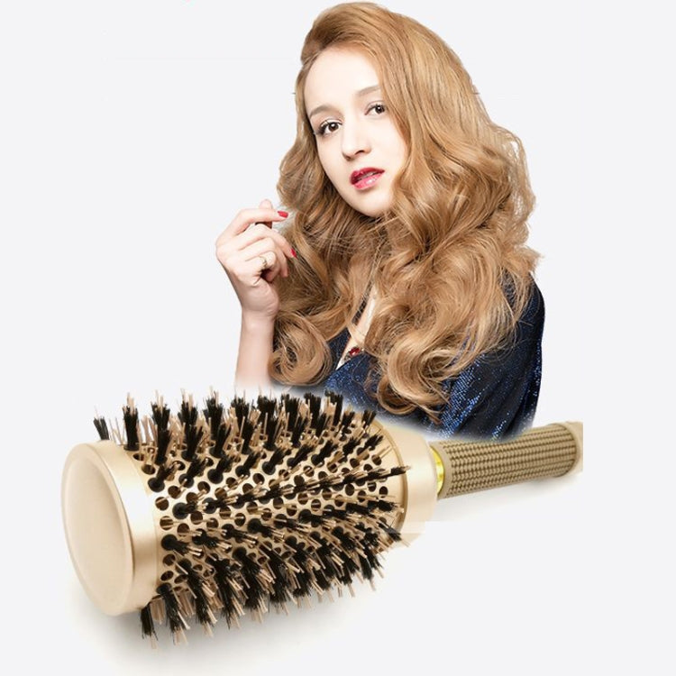 Ceramic roller hair brush with gold barrel and black bristles held near styled hair