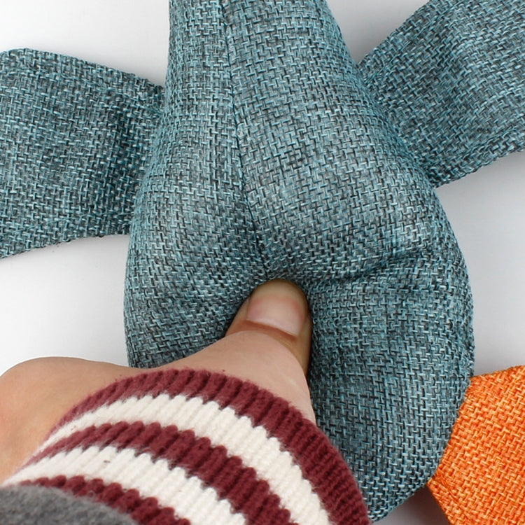 Close-up of blue-gray plush goose dog toy fabric with orange feet and hand grip