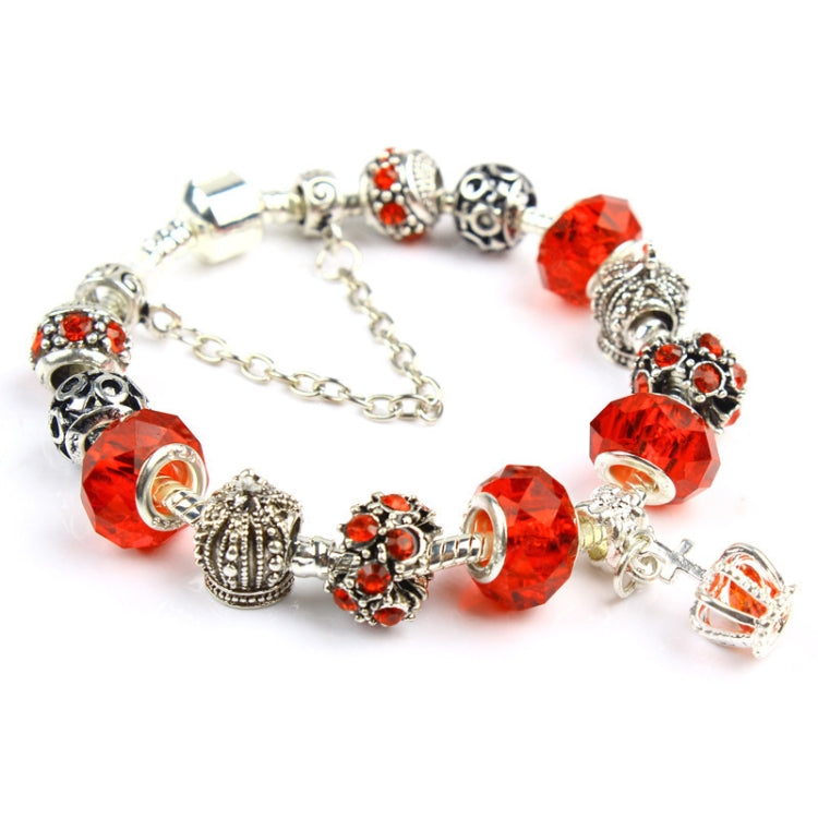 Charm bracelet with red faceted crystal beads, silver-tone filigree charms, and chain links