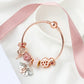 Rose gold charm bracelet with heart lock bead, pink heart charms, and dangling letters