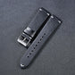 Leather watch strap in dark gray with metal buckle and row of adjustment holes
