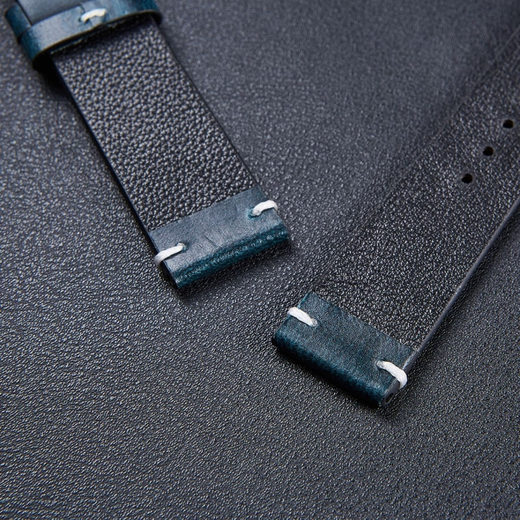 Dark leather watch strap close-up with pin buckle tabs and punched strap holes