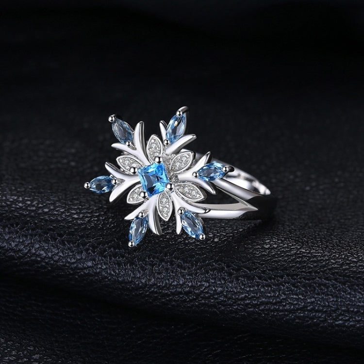Sterling silver snowflake flower ring with bright blue topaz center and side stones