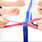 Children walking rope held by hands, showing multi-color connecting straps