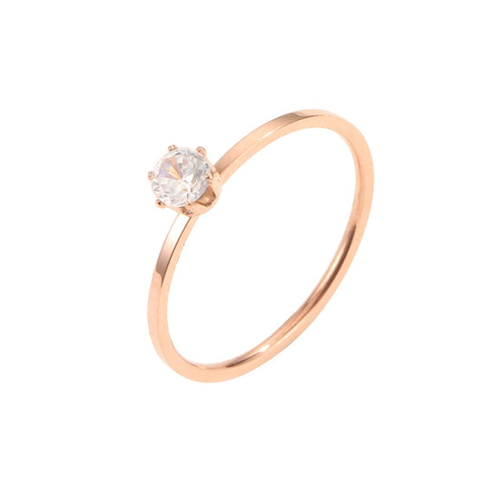 Rose gold-tone diamond ring featuring a round center stone with six claws