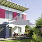 Garden sunshade sail canopy installed over outdoor seating, white fabric