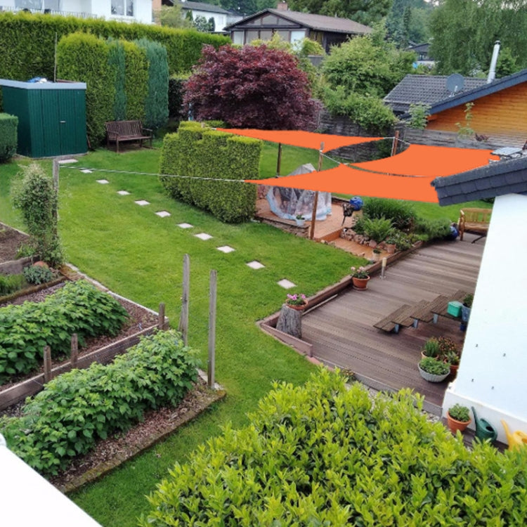Orange waterproof shade sail canopy stretched over a garden yard