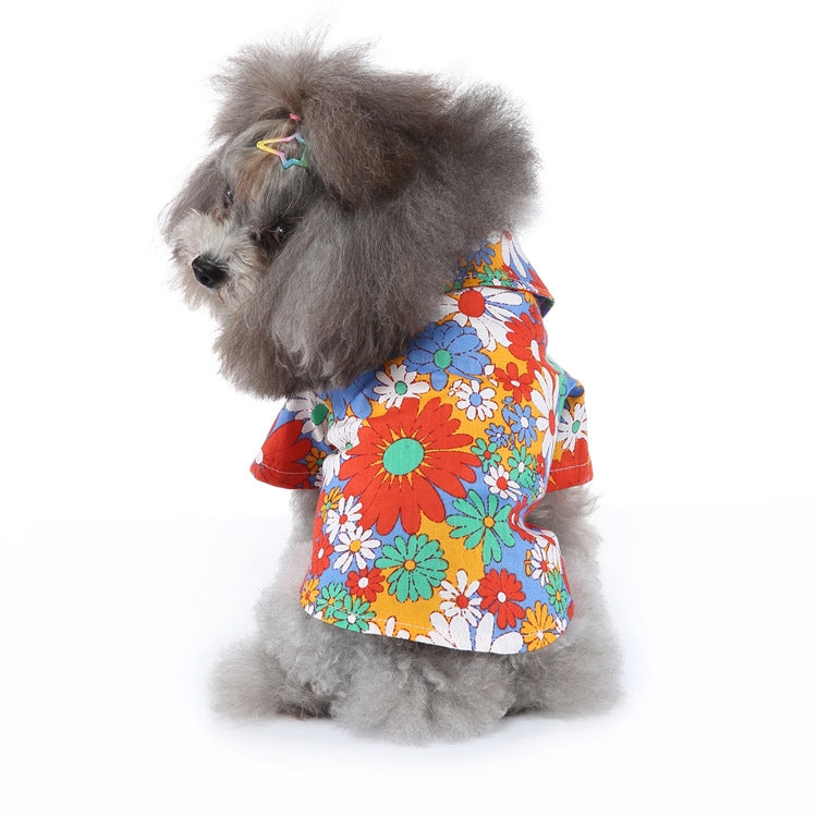 Dog summer shirt with colorful flower print on bright orange fabric.