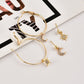 Gold-tone hoop earrings with crescent moon and star charms, arranged on a striped card