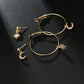 Gold-tone hoop earrings with star and crescent moon charms on a dark surface