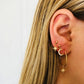 Gold-tone hoop earrings with dangling crescent moon, star, and small crystal charms