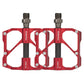 Red aluminum/carbon fiber bicycle platform pedals, dual studs and threaded axle.