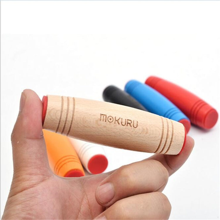 Hand holding a natural wood flip stress-relief toy stick with grooved rings
