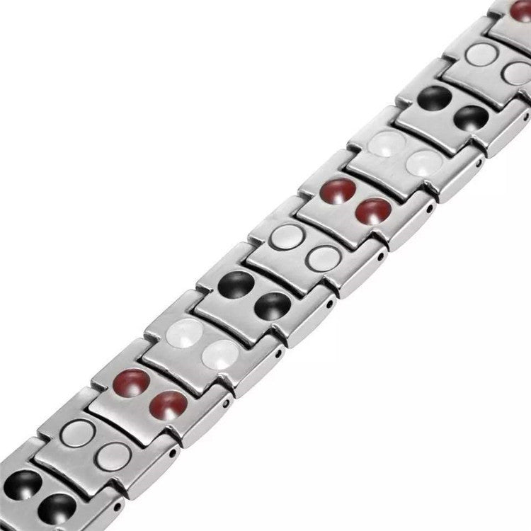 Close-up of silver magnetic bracelet links with red and white circular magnet insets