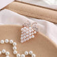 Grape-shaped pearl and rhinestone brooch close-up with rose-gold tone frame