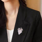 Grape-shaped pearl and rhinestone brooch on black blazer lapel