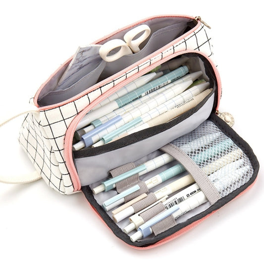 Canvas pencil case with zipper open; white grid pattern with pink trim, showing pen compartments