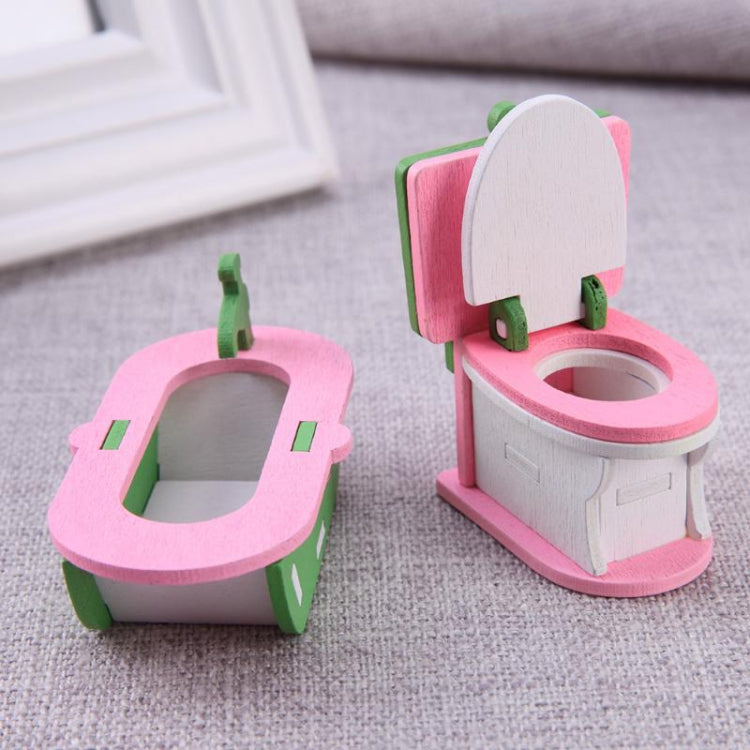 Miniature wooden bathroom set with pink toilet, mirror back, and green side fixtures