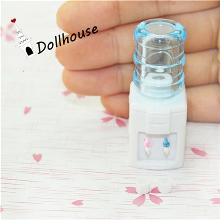 Miniature water dispenser toy held in hand, blue reservoir and white dual taps
