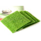 Neatly stacked green artificial turf mats, folded sheets with textured faux moss fibers