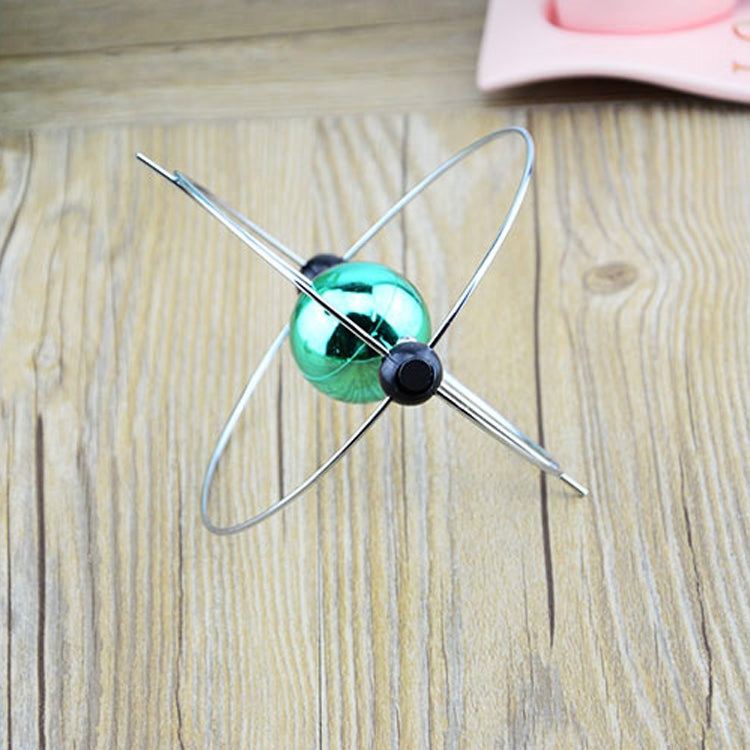Close-up of rotating magnetic globe ornament with teal sphere and black magnetic pins