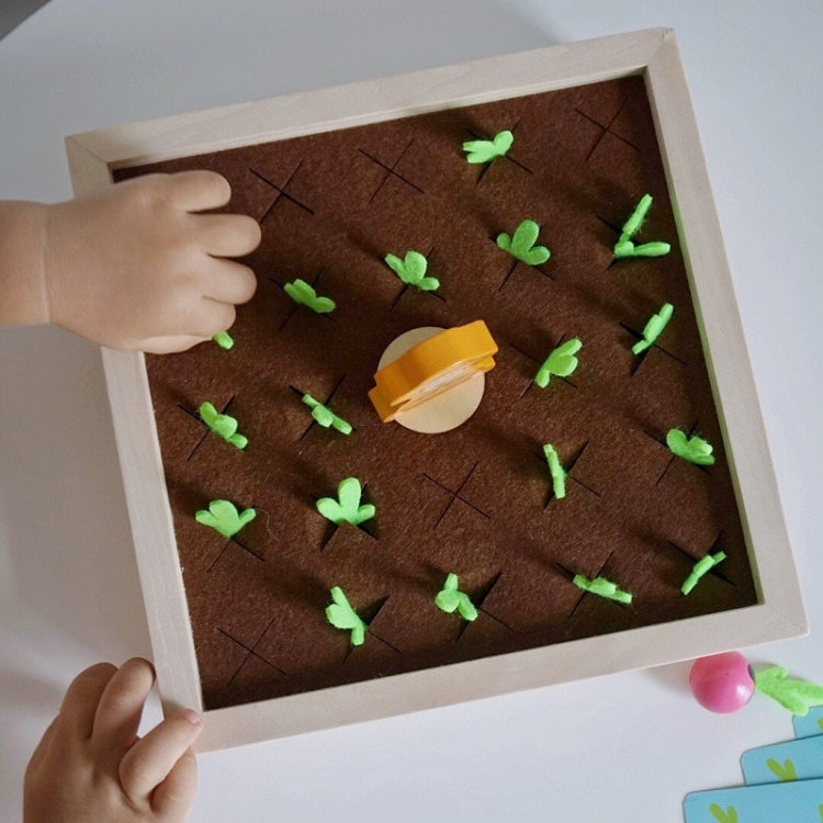 Child hand playing wooden carrot memory board with green carrot pegs