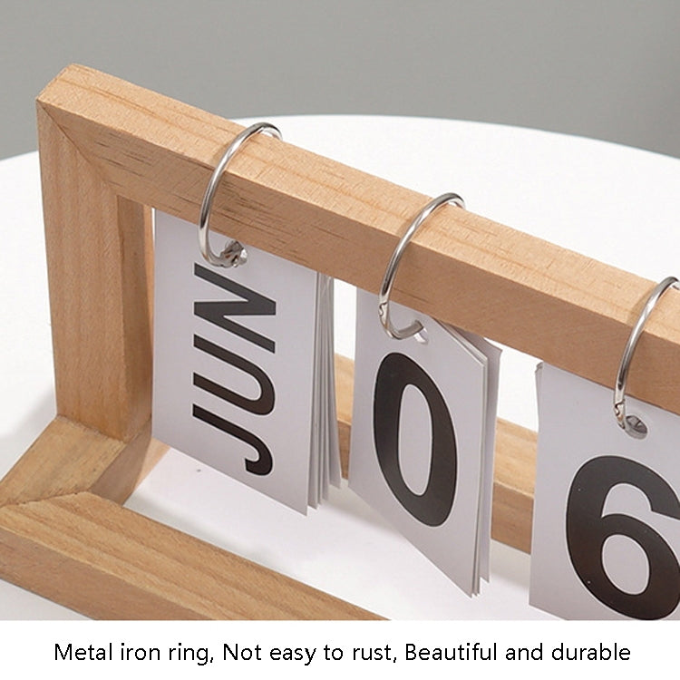 Close-up of wooden flipping desk calendar with metal rings and cards showing JAN 06