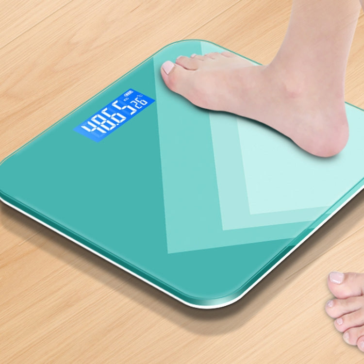 Teal smart electronic scale with blue LCD weight display under a person’s foot