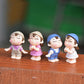 Set of 4 mini cartoon house figurines on a surface: purple, pink, blue, and white