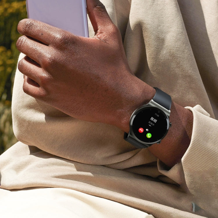 Smartwatch on wrist with black band and dark face, worn with a light beige sleeve