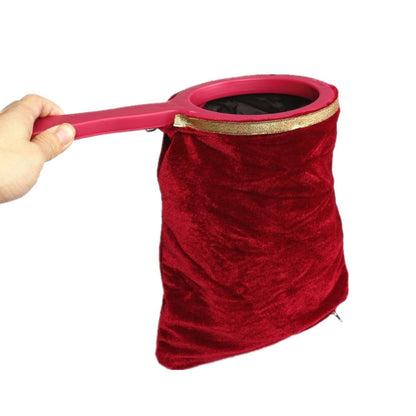 Red velvet magic change bag prop with pink handle and gold-trimmed rim.