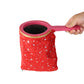 Red star-pattern change bag prop with pink handle and gold-trimmed opening.