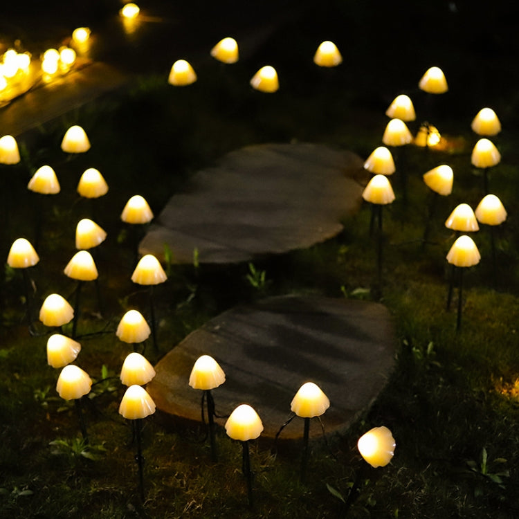 Outdoor solar mushroom string lights with warm yellow glow along a garden path